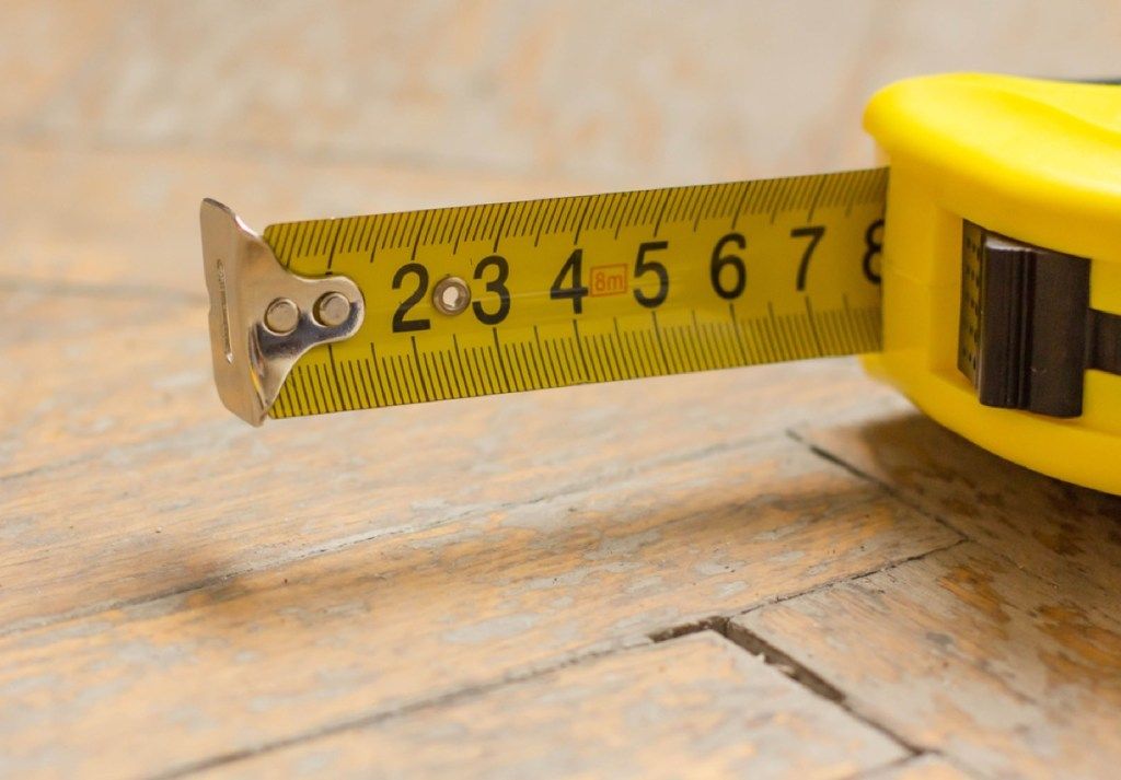 cinta métrica amarilla, reduciendo el tamaño de su hogar