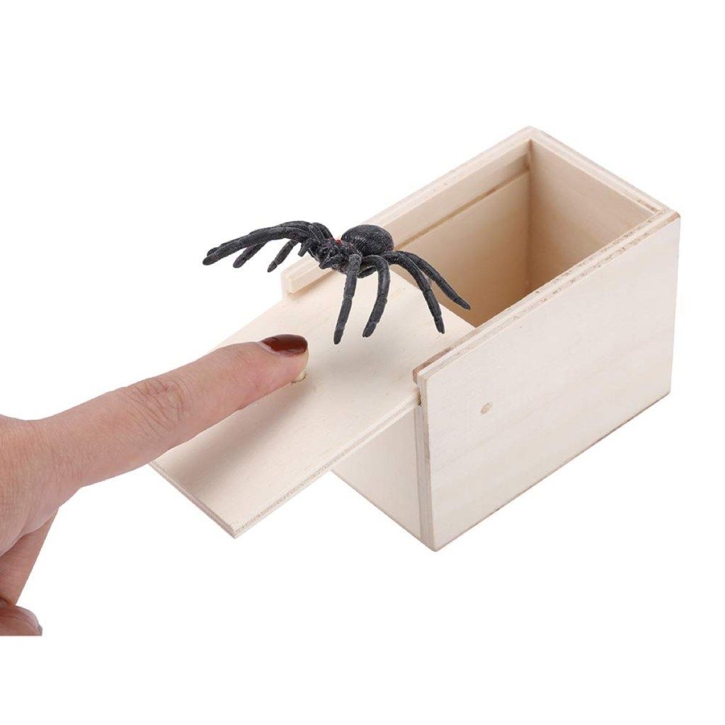 hvid hånd og edderkop kommer ud af kassen