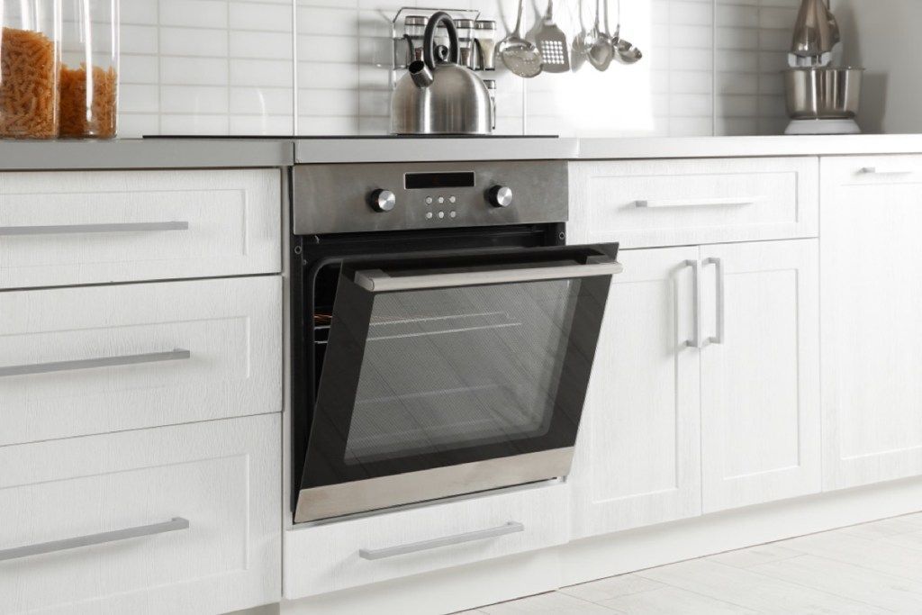 תנור נירוסטה פתוח במטבח מודרני לבן, טיפים למניעת שריפה