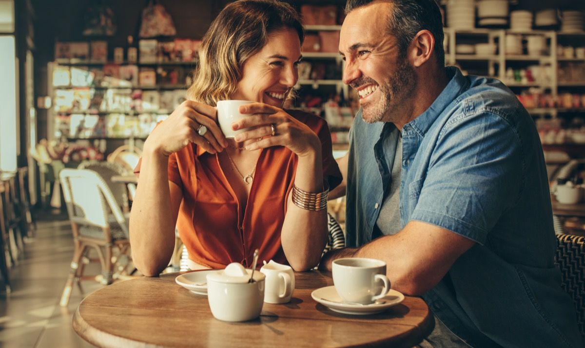 Vīrietis un sieviete sēž tuvu kafejnīcā