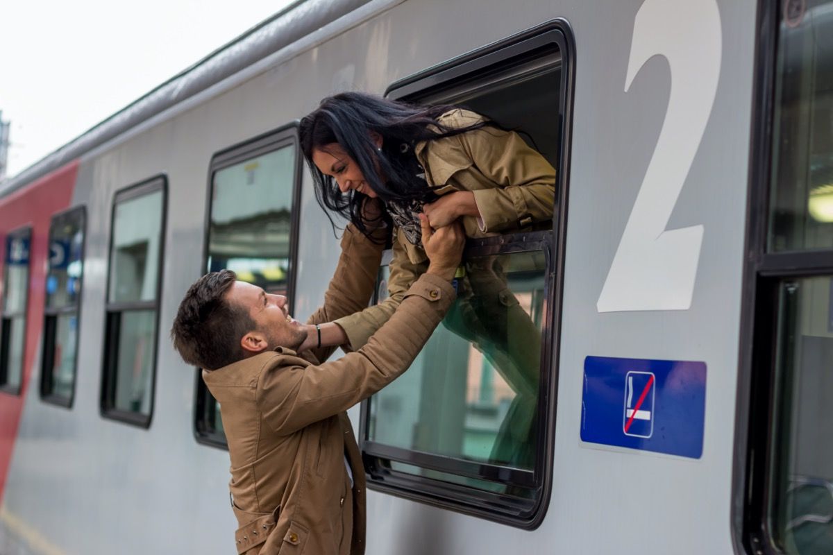 Vyras ir moteris atsisveikina pro traukinio langą