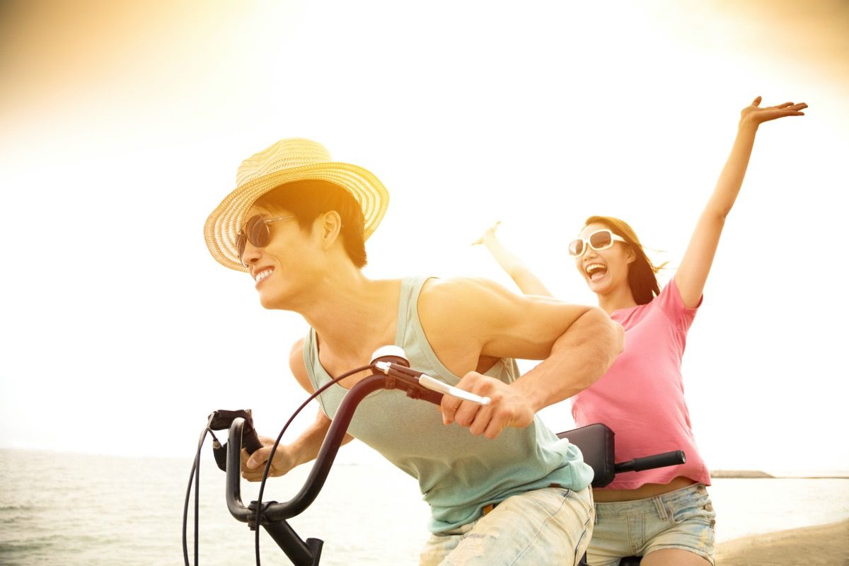 Vyras ir moteris, važiuojantys tandeminiu dviračiu