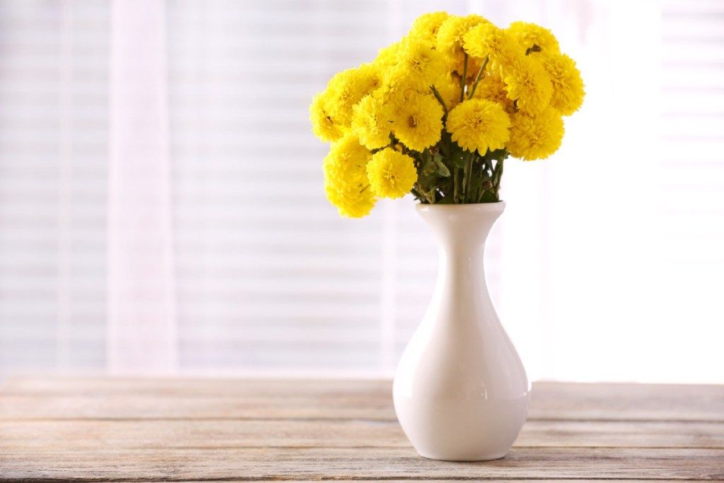 gele bloemen in witte vaas, ouderwetse schoonmaaktips