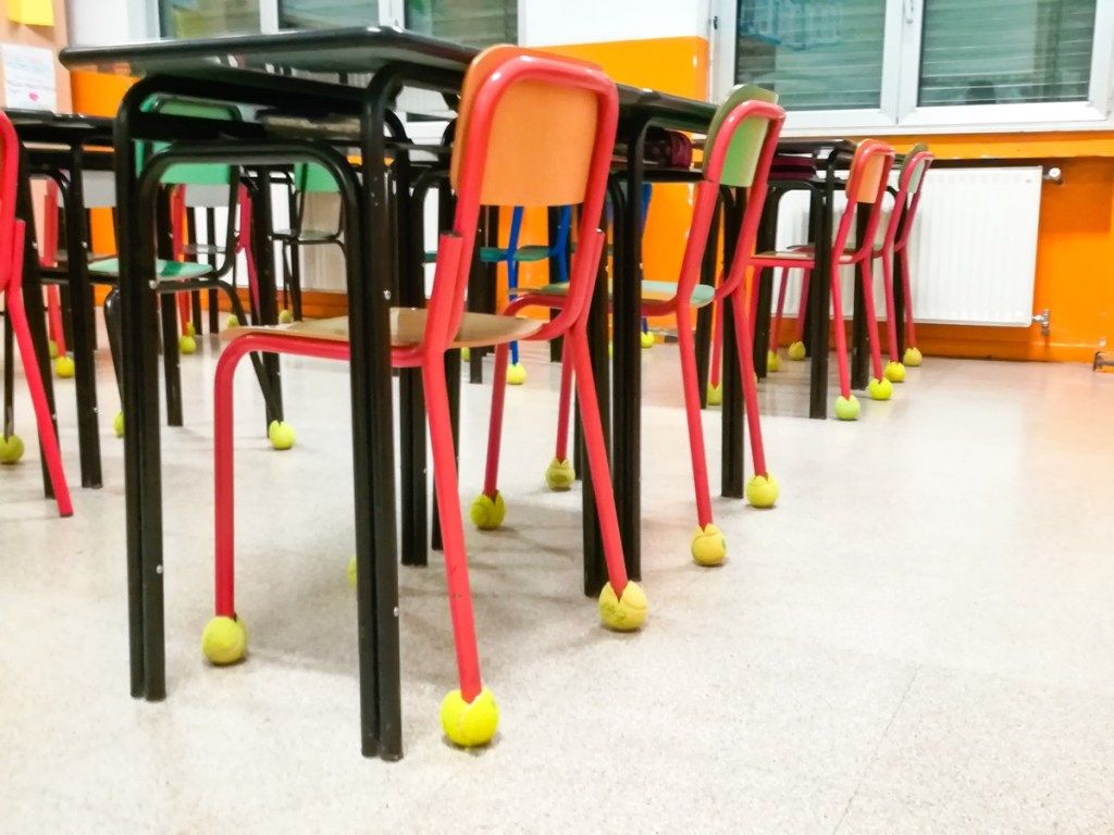 Столове в клас в един ред с тенис топка като брони