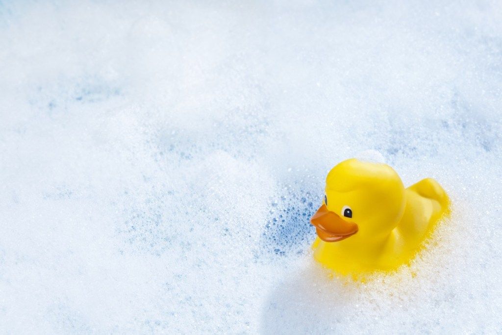 Um pato de borracha amarela na banheira.