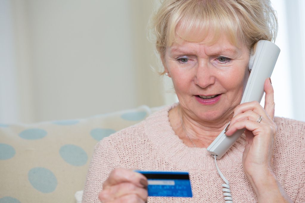 nainen antaa luottokorttitiedot puhelimitse