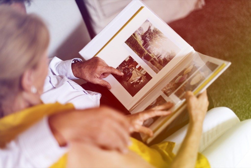 Пожилая белая пара смотрит на фотоальбом