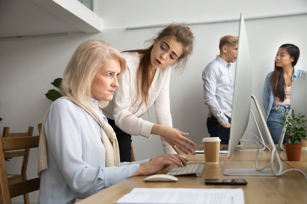 ผู้หญิงกำลังโกรธเพื่อนร่วมงานที่มีอายุมากกว่าในคอมพิวเตอร์