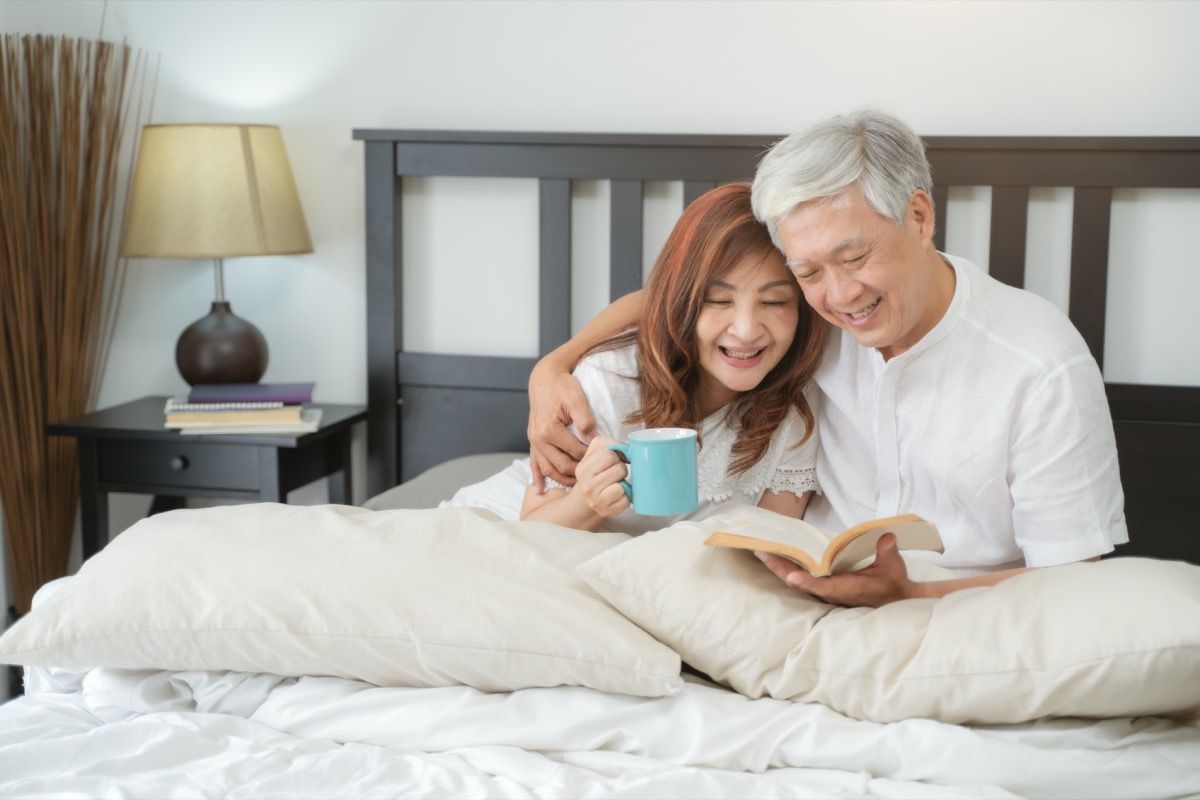 двойка, която чете книга в леглото