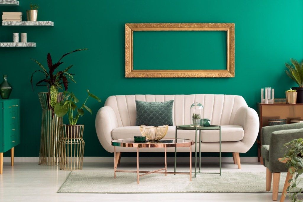avrundet beige sofa mot grønn vegg