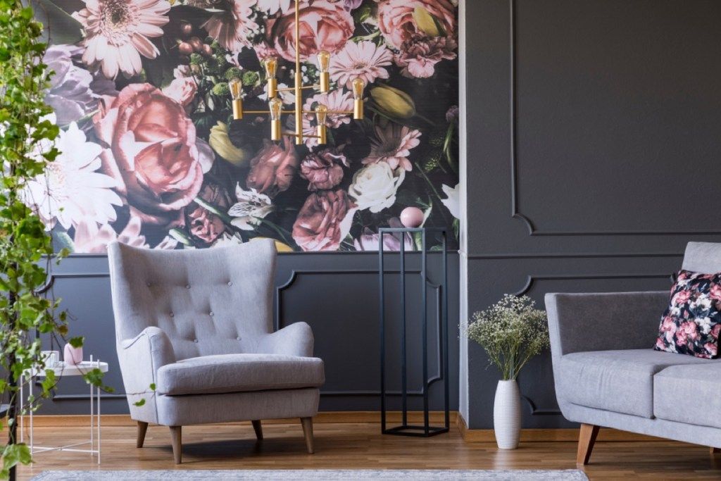 dnevni boravak s cvjetnim tapetama, sivim zidovima i sivom stolicom
