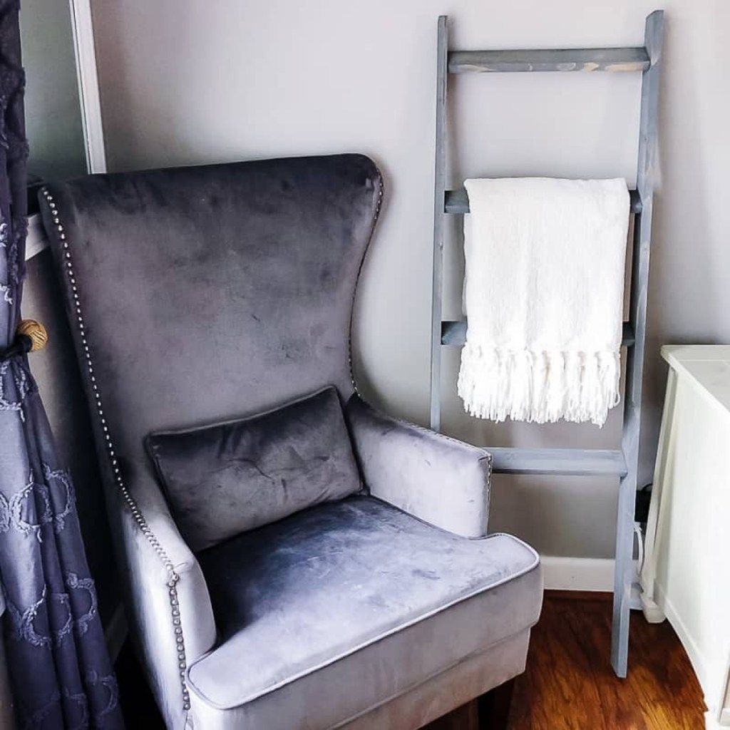 silla gris junto a la escalera con una manta