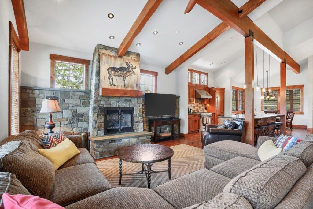 sala de estar con sofás grises y techo con vigas de madera