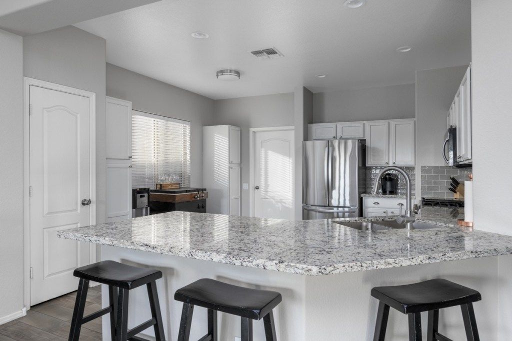 granit tezgahlı ve siyah tabureli modern mutfak