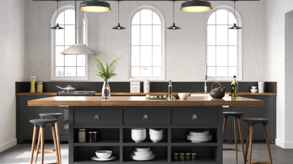 moderní kuchyň s černým ostrůvkem s pulty řeznických bloků a závěsným osvětlením