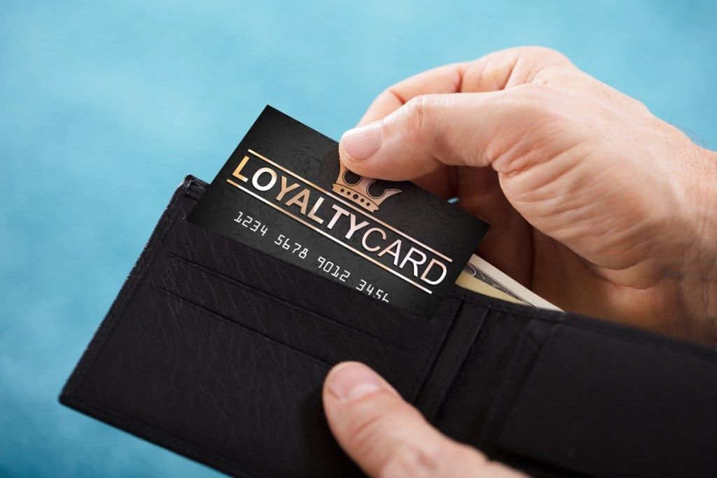 Mężczyzna wyciąga kartę lojalnościową z portfela