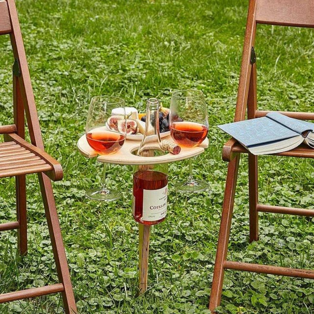вино на дървена маса и столове на трева