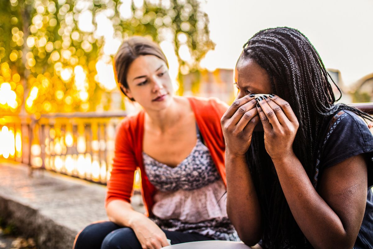 чернокожа жена плаче, докато бялата жена я утешава