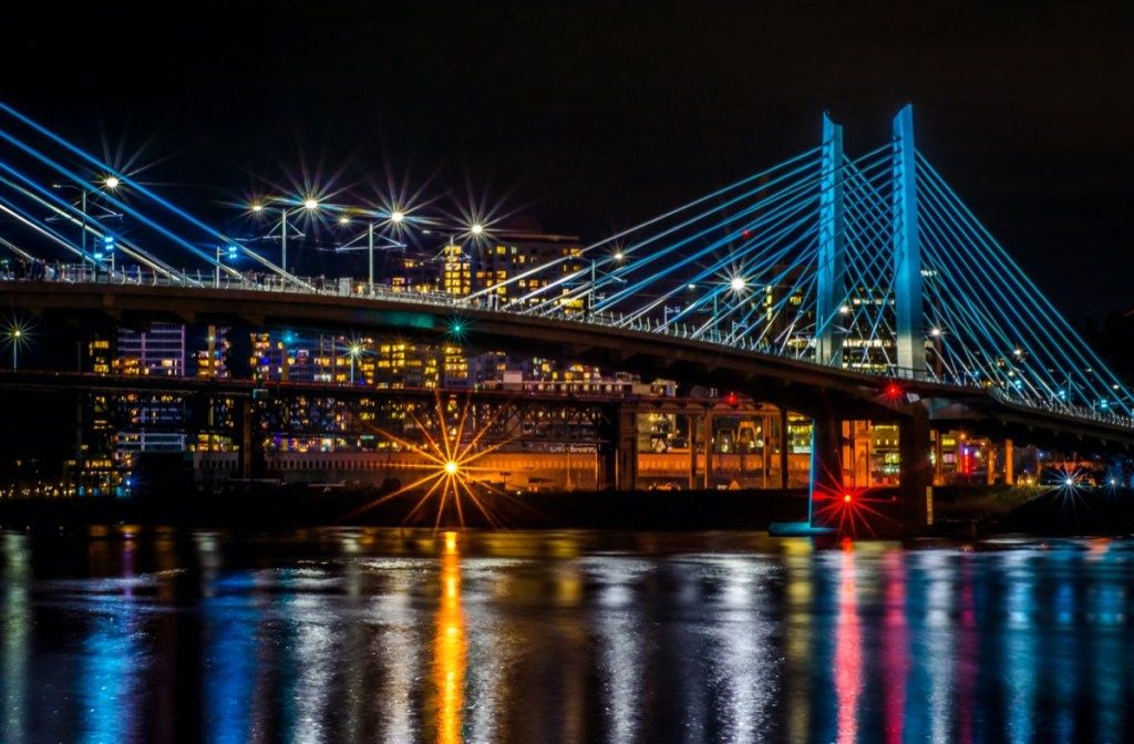 ภาพถ่ายทิวทัศน์ของสะพานเหนือทะเลสาบและอาคารในพอร์ตแลนด์รัฐโอเรกอนตอนกลางคืน