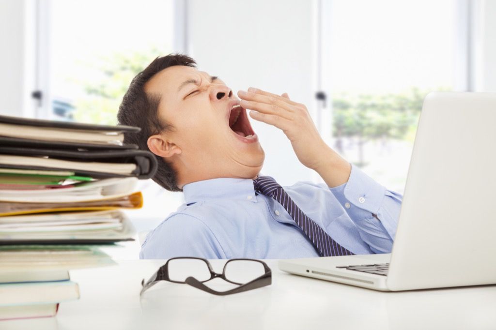 Homem bocejando no trabalho. fatos impressionantes