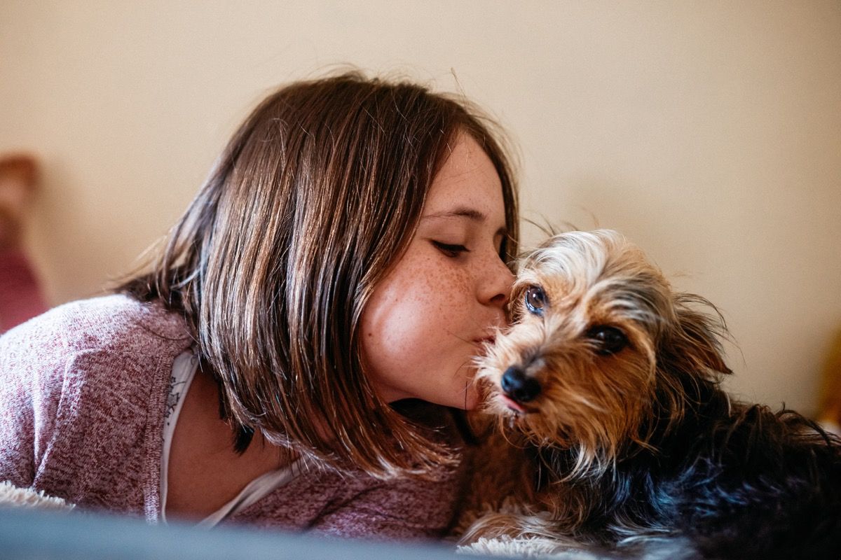 oříznutý snímek rozkošné mladé dívky spoutané se svým psem