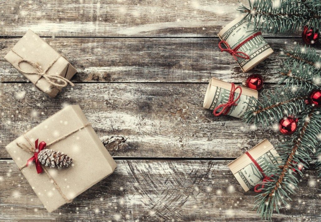 hadiah natal dan uang dengan latar belakang kayu