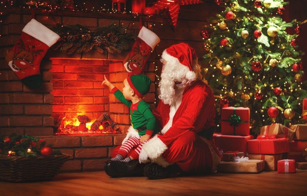 Moș Crăciun și Elf în fața șemineului