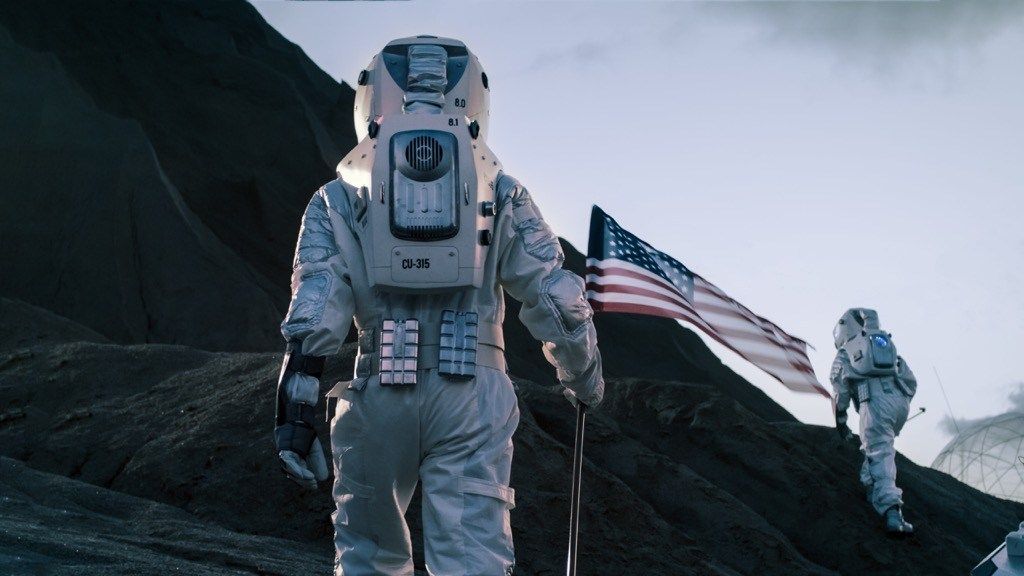 अमेरिकी ध्वज के साथ चंद्रमा पर चलने वाले अंतरिक्ष यात्री