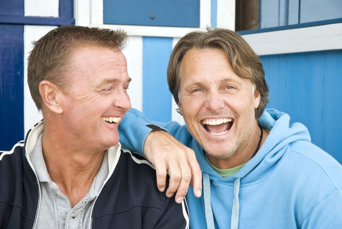 دو آدمی ایک ساتھ ہنس رہے ہیں