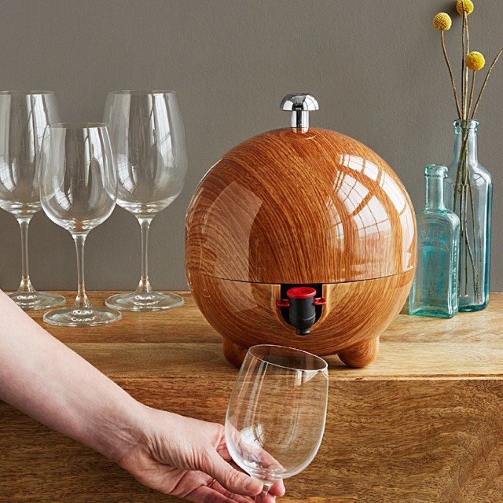 barril de vinho redondo no balcão com taças de vinho e garrafas