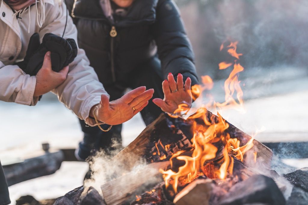 Beberapa wanita tua yang aktif sedang memanaskan diri dengan api unggun pada hari musim sejuk yang indah di Sweden.