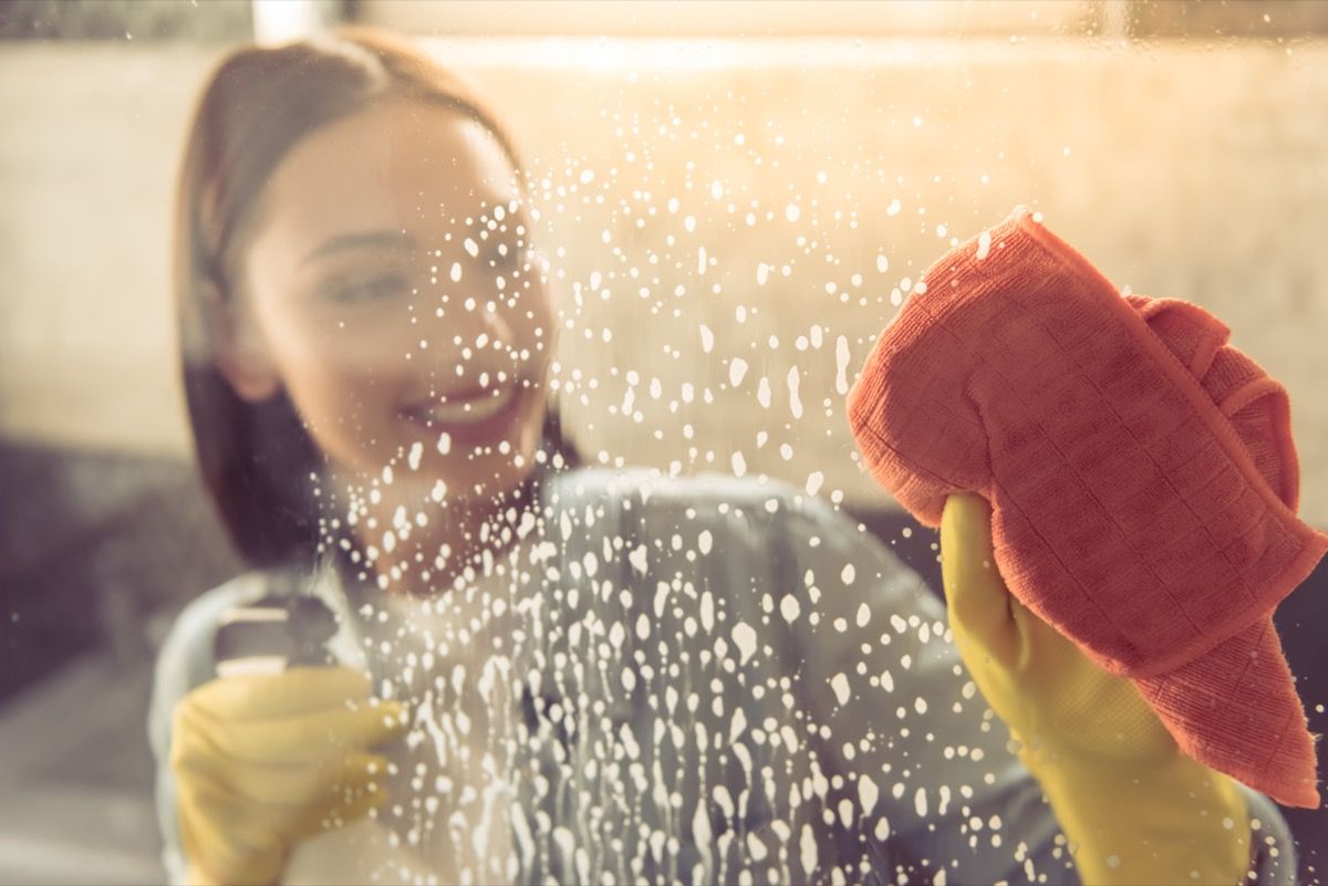 Nainen puhdistaa suihkua