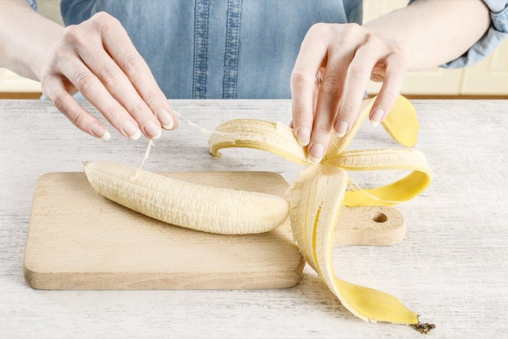nainen kuorii banaania phloem-nippuilla