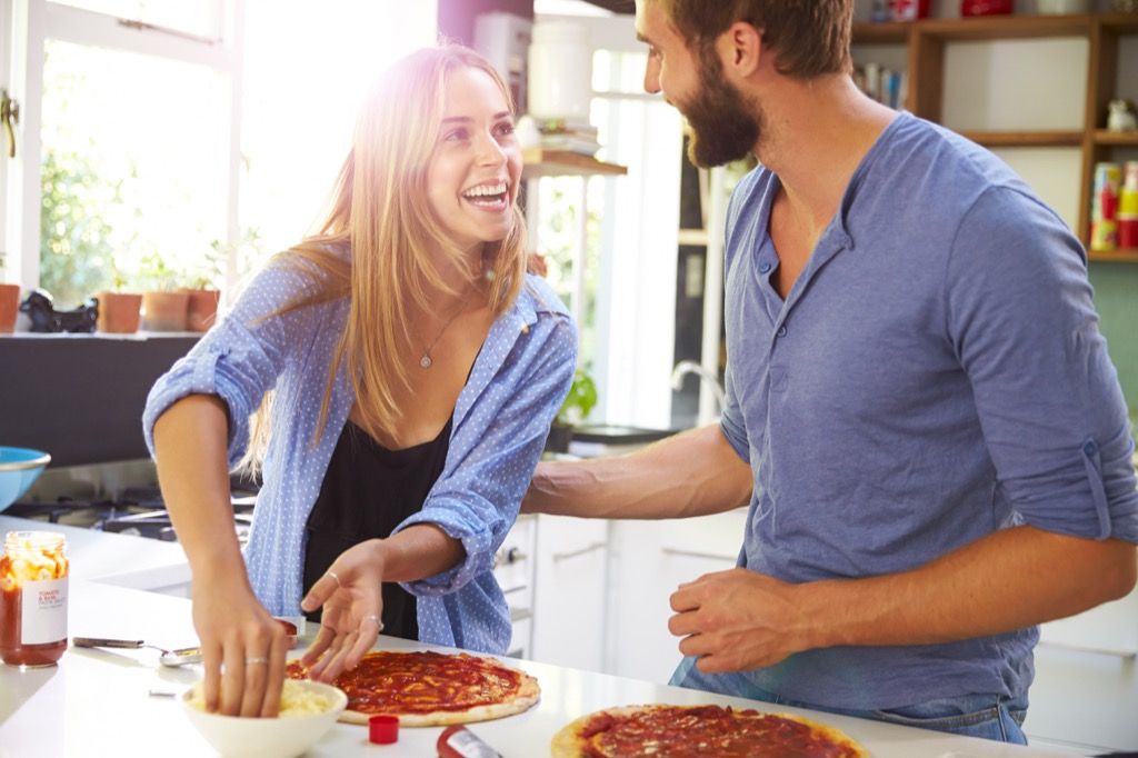 привлекателна двойка, която прави пица у дома