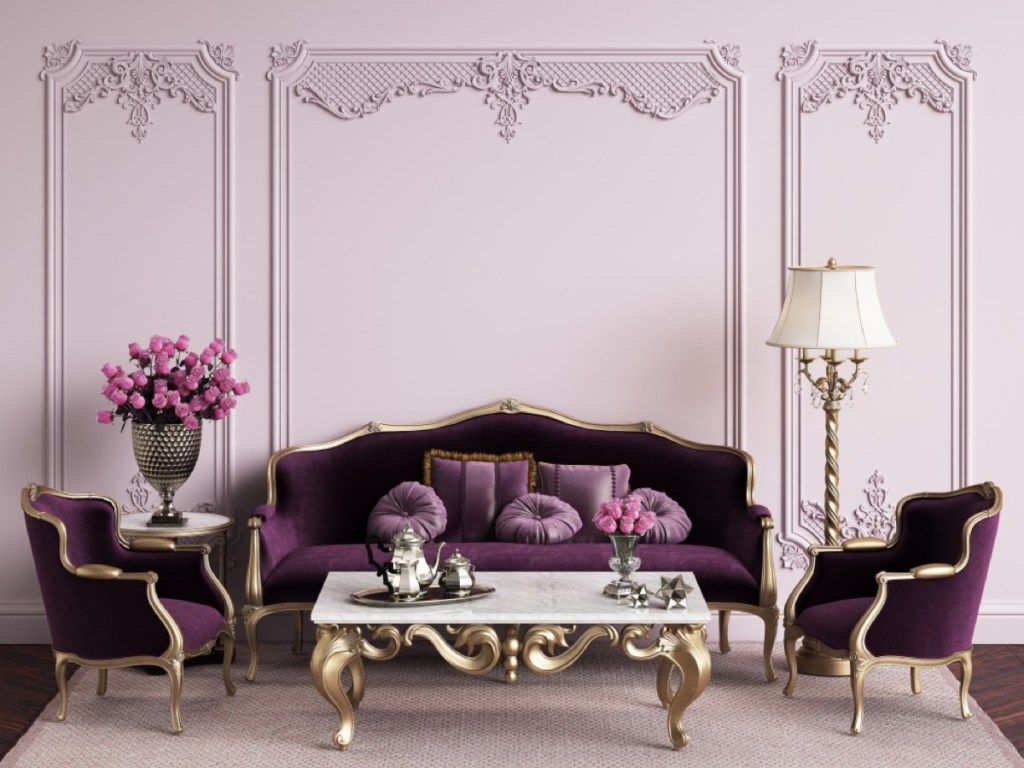 fialová obývacia izba s fialovým zamatovým gaučom a zlatým stolom