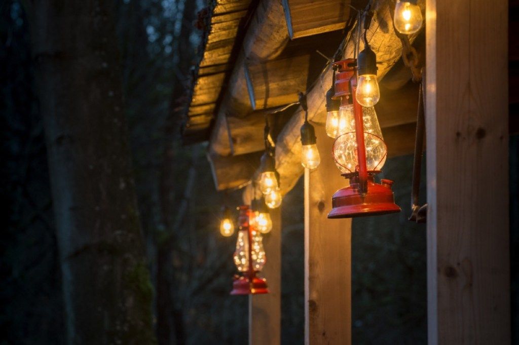 domáci exteriér s červenými búrkovými lampiónmi a mihotavými svetlami