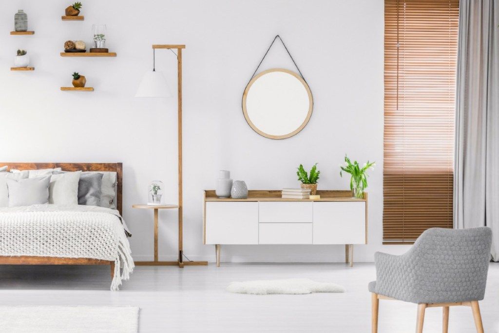 Miroir rond sur le mur dans une chambre minimaliste scandinave