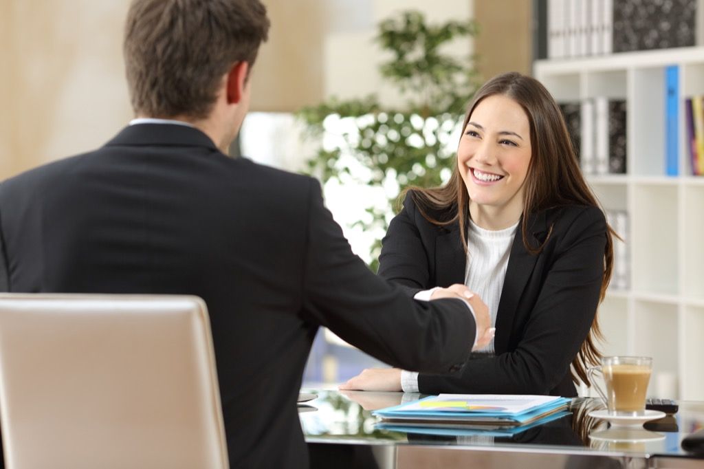 Um empresário entrevistando uma mulher para um emprego maneiras de obter uma promoção após os 40