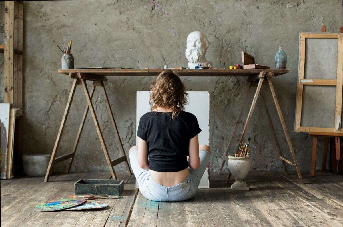 Moteris tapyba sėdi ant grindų