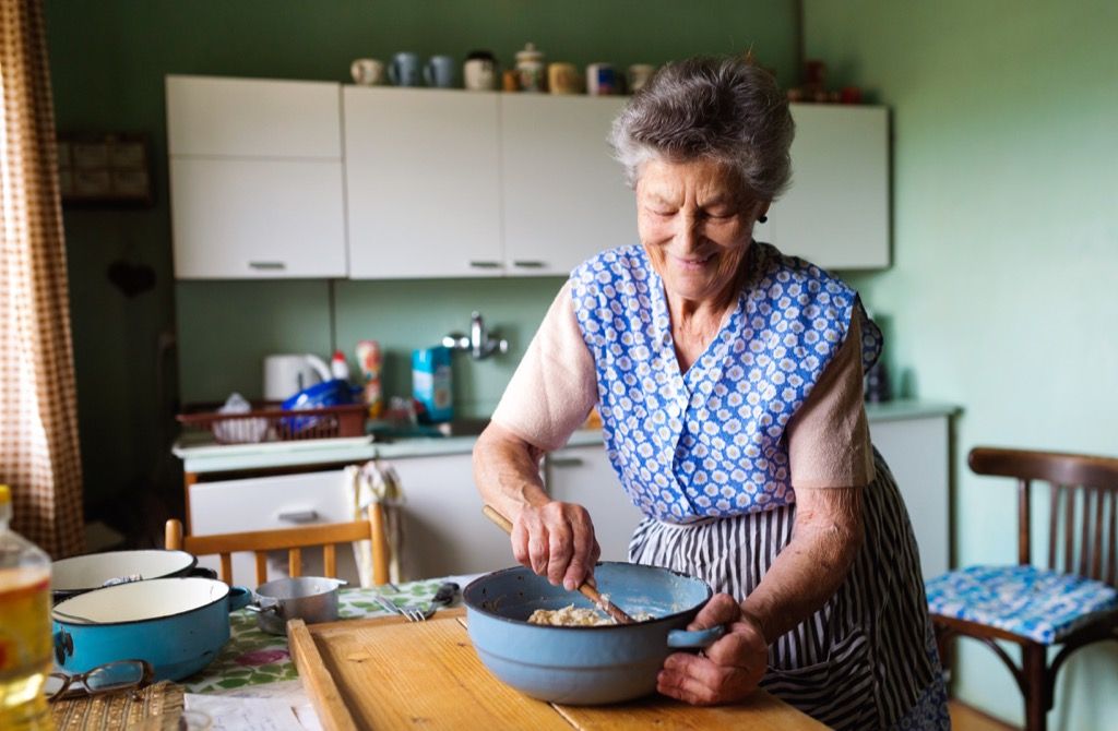 Gammel kvinne, bestemor på kjøkkenet og lage mat