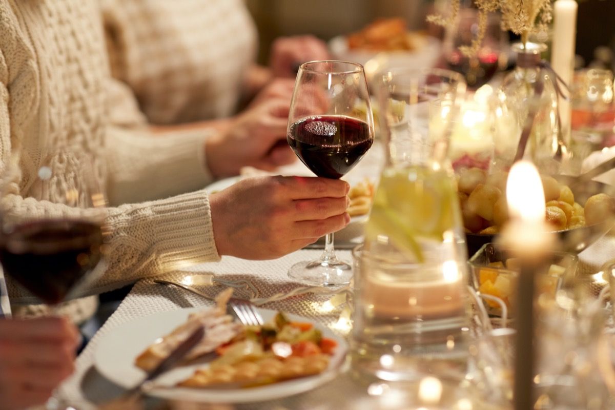 Gente bebiendo vino tinto con cena de Acción de Gracias.