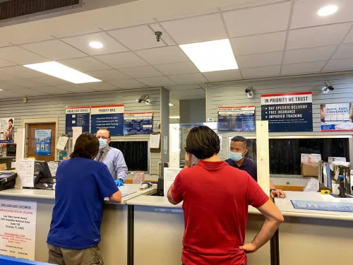  Inimesed saadavad pakke Ameerika Ühendriikide Florida osariigi Orlando postkontorisse, kus inimesed kannavad näomaske ja hoiavad sotsiaalset distantseerumist,