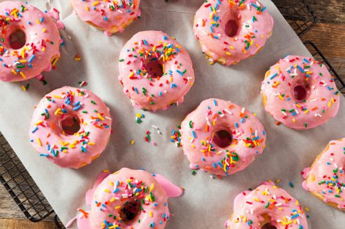   Hjemmelavede søde donuts med lyserød frosting og drys