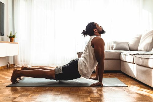   Un hombre haciendo yoga en su salón.