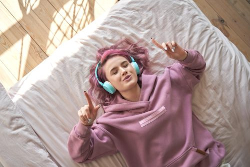   mladi tinejdžer s ružičastom kosom sluša glazbu