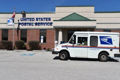   King of Prussia, PA/USA-2020년 4월 7일: 미국 우체국 트럭은 COVID-19 바이러스 동안 우편물을 픽업하기 위해 우체국 건물 밖에 주차합니다.