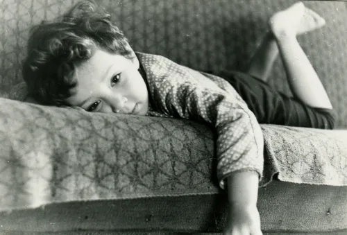   vintage fotoattēls ar mazu zēnu, kas guļ uz dīvāna