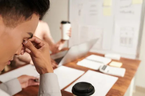   Уморен бизнесмен, който търка носа си след стресираща среща в офиса