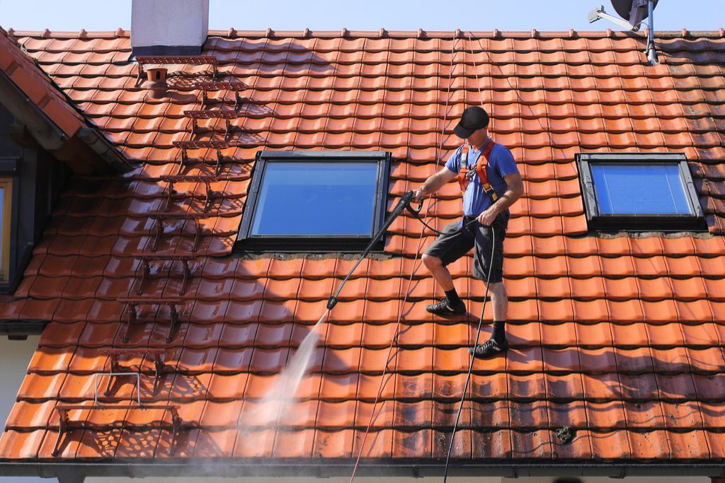 Човек, който почиства покрива, засилва дома ви
