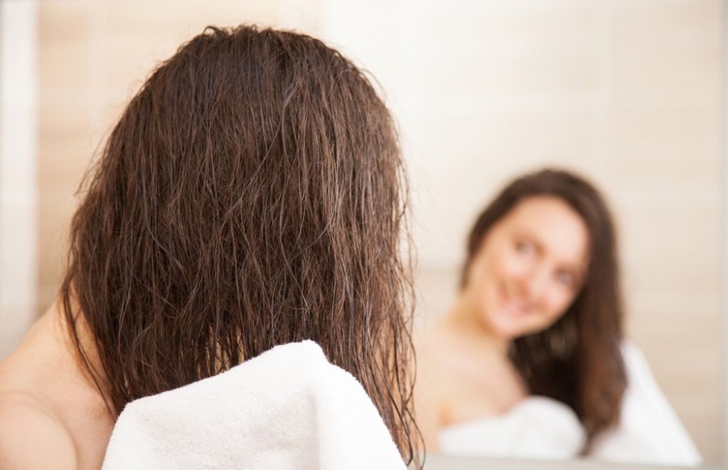 moteris po dušo šlapiais plaukais